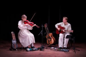 I Västanå Musik & Teater föreställning Tiggarfolk & Herrskap, får du möta berättelser från flera av Selma Lagerlöfs verk som kretsar runt Lövdala. Förebilden är Selmas eget barndomshem Mårbacka. På bilden En kvinna som spelar nyckelharpa och en man som spelar fiol.