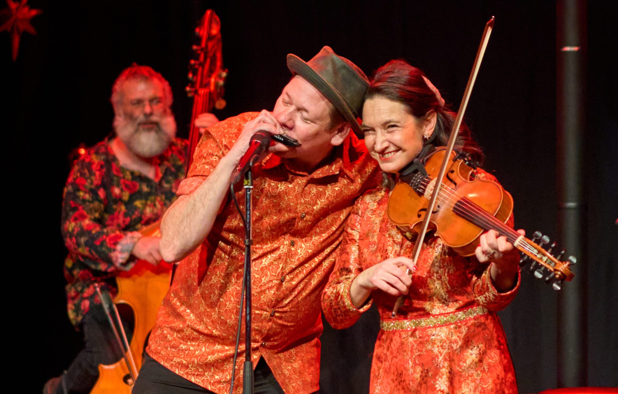 Livebild på Magnus och Sophia Stinnerbom med Sébastien Dubé i bakgrunden. Från konserten Västanå Jul 2023.